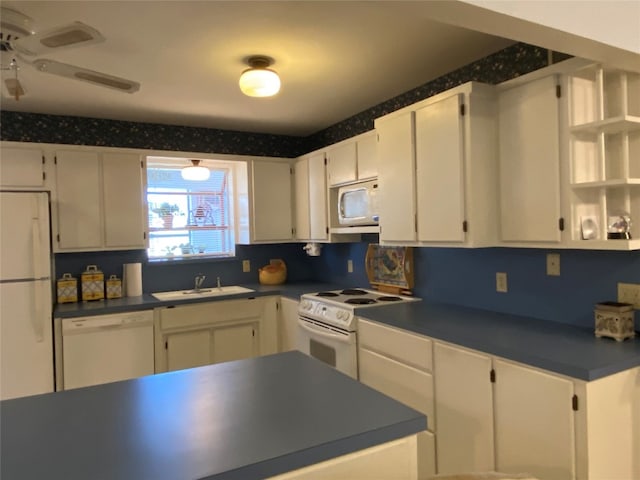 kitchen featuring white appliances, ceiling fan, sink, and white cabinetry