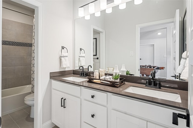 full bathroom featuring toilet, vanity, tiled shower / bath, and tile patterned flooring