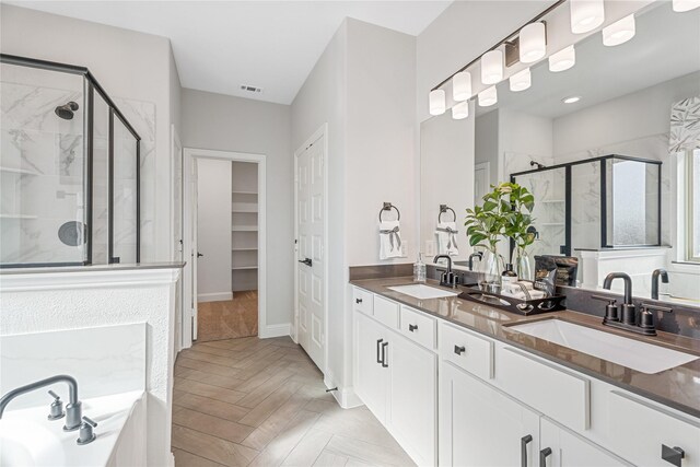 bathroom featuring parquet flooring, independent shower and bath, and vanity