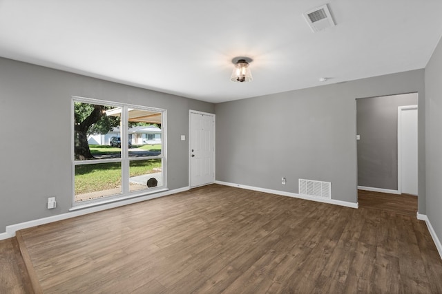 unfurnished room with dark wood-type flooring