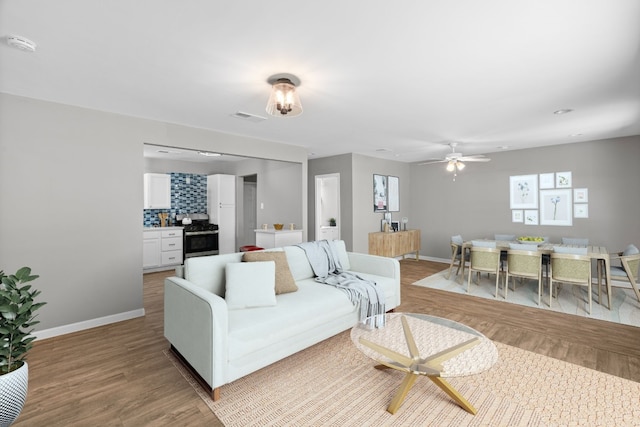 living room with light hardwood / wood-style flooring and ceiling fan