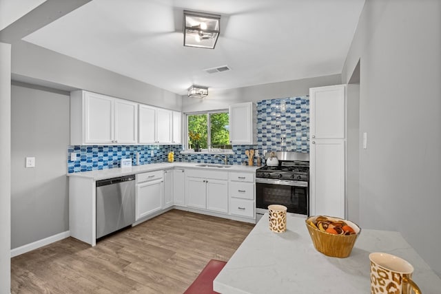 kitchen featuring sink, light hardwood / wood-style flooring, stainless steel appliances, and light stone countertops