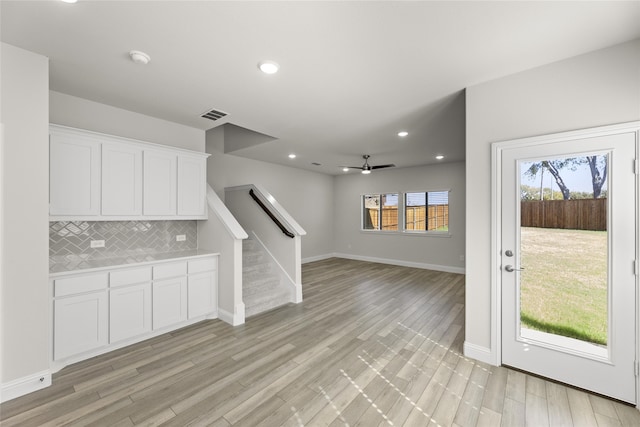 kitchen with decorative backsplash, ceiling fan, light hardwood / wood-style flooring, and white cabinets