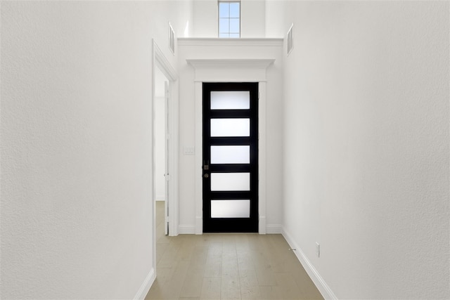 doorway to outside featuring light wood-style floors, visible vents, and baseboards