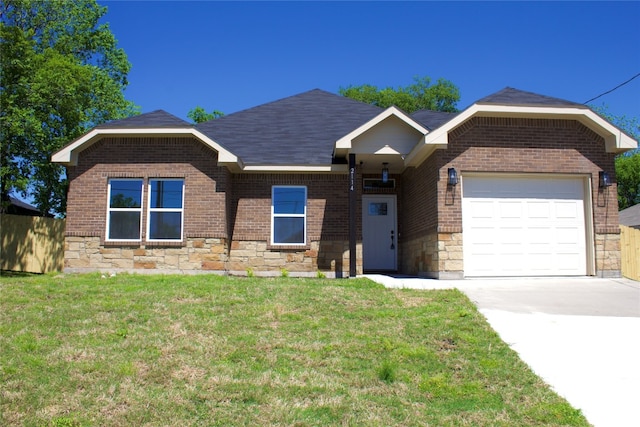 ranch-style home featuring brick siding, stone siding, an attached garage, and a front lawn