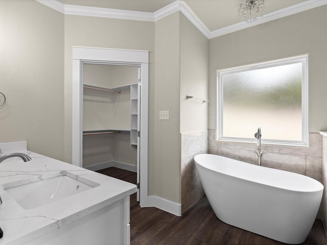 bathroom with hardwood / wood-style floors, ornamental molding, tile walls, and a washtub