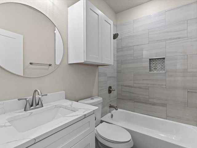 full bathroom with vanity, tiled shower / bath combo, and toilet