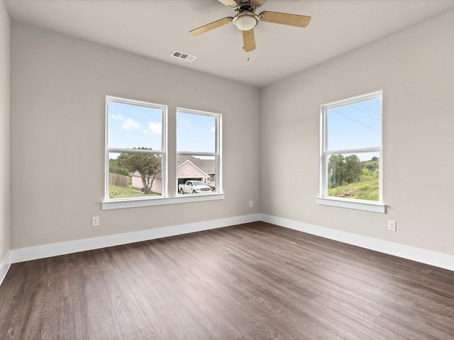 unfurnished room featuring ceiling fan, plenty of natural light, and dark hardwood / wood-style flooring