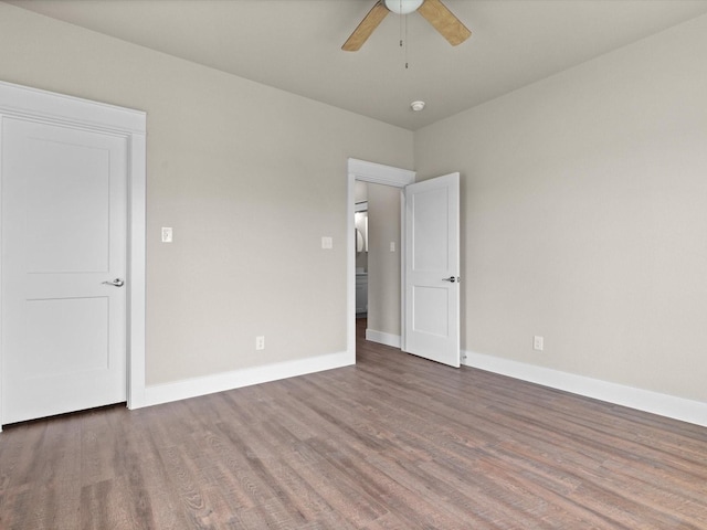 unfurnished room featuring ceiling fan and dark wood-type flooring