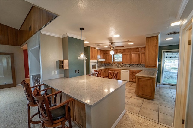 kitchen featuring kitchen peninsula, hanging light fixtures, white appliances, ceiling fan, and tasteful backsplash