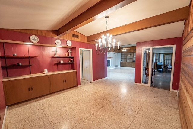 kitchen featuring a notable chandelier, wood walls, lofted ceiling with beams, and light tile floors