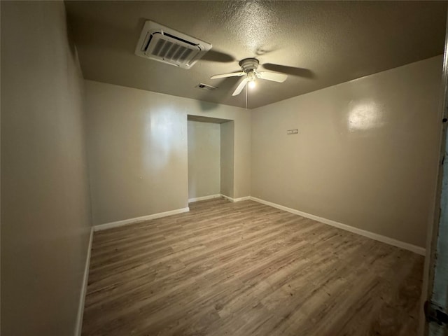 empty room featuring wood-type flooring, ceiling fan, and a textured ceiling