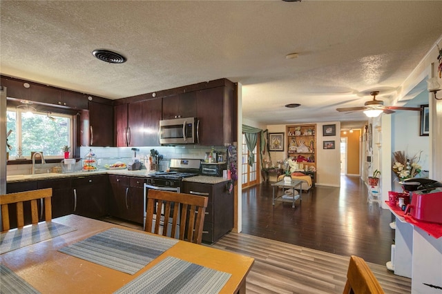 kitchen with ceiling fan, stainless steel appliances, light hardwood / wood-style floors, a textured ceiling, and sink