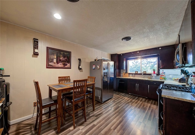 dining room with sink, dark hardwood / wood-style floors, and a textured ceiling