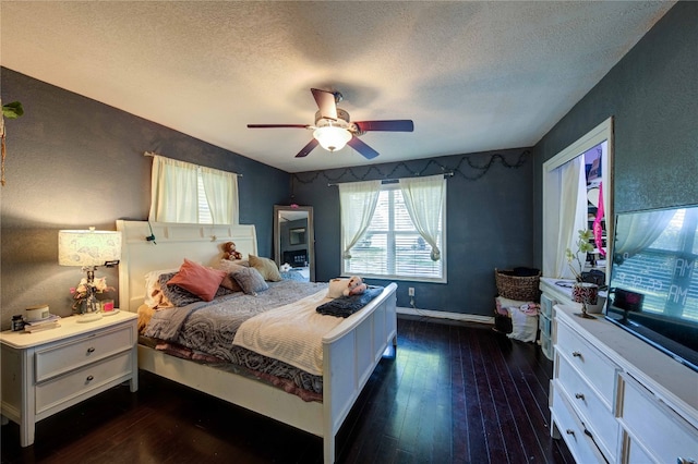 bedroom featuring ceiling fan, dark hardwood / wood-style floors, and a textured ceiling