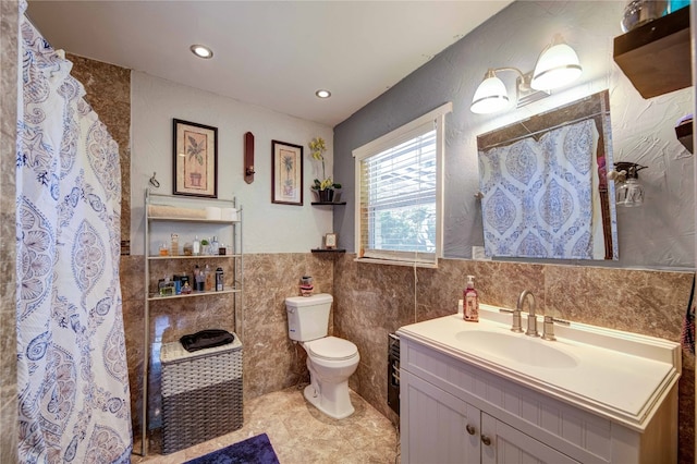 bathroom featuring tile walls, vanity, toilet, and tile flooring