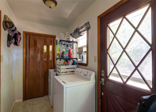 washroom featuring a healthy amount of sunlight, washer / clothes dryer, and light tile flooring