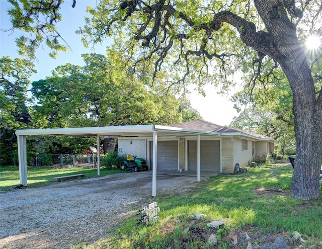 view of front facade with a garage, a carport, and a front lawn