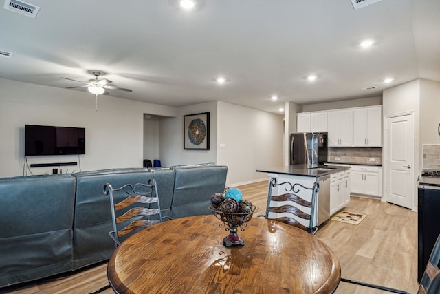 dining space with light hardwood / wood-style floors and ceiling fan