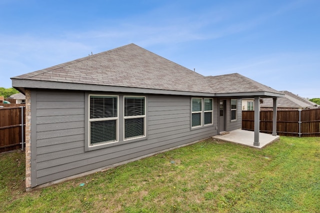 rear view of house with a patio and a lawn