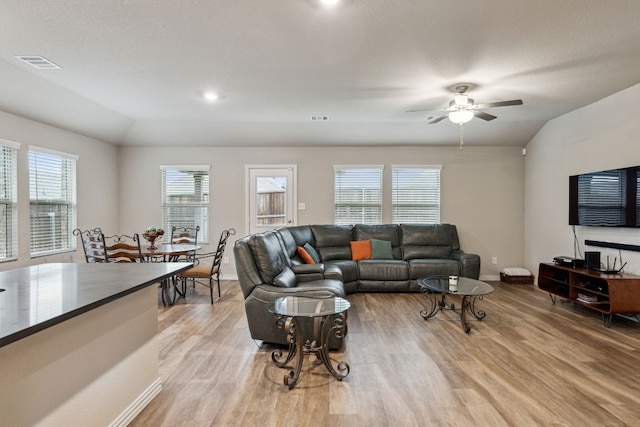 living room with light hardwood / wood-style flooring, ceiling fan, and lofted ceiling