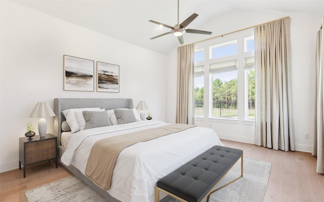 bedroom featuring ceiling fan, light hardwood / wood-style floors, and lofted ceiling