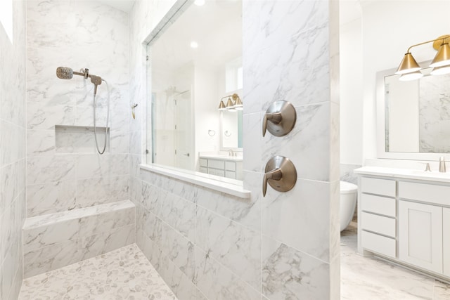 bathroom with vanity, toilet, and a tile shower