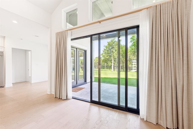 doorway featuring french doors, high vaulted ceiling, and light hardwood / wood-style floors