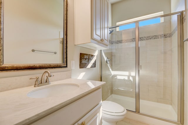 bathroom featuring toilet, a shower with shower door, and vanity