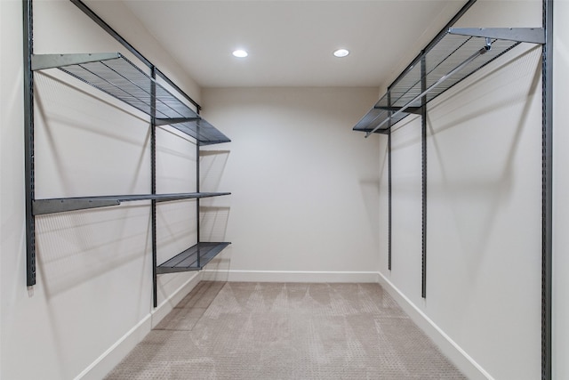 walk in closet featuring light carpet