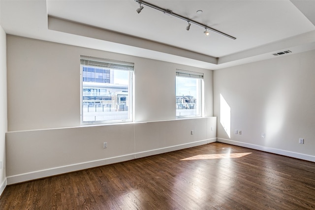 unfurnished room with rail lighting and dark hardwood / wood-style flooring