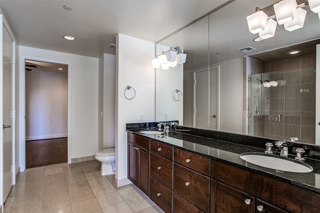 bathroom with a shower with door, toilet, tile floors, and dual bowl vanity