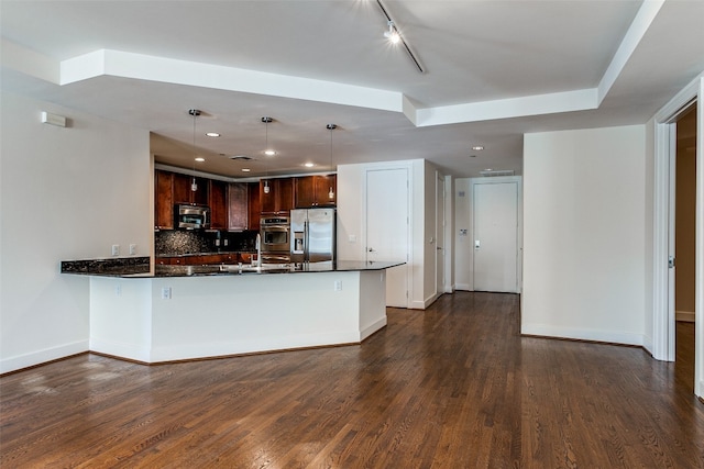 kitchen with hanging light fixtures, appliances with stainless steel finishes, tasteful backsplash, and dark wood-type flooring