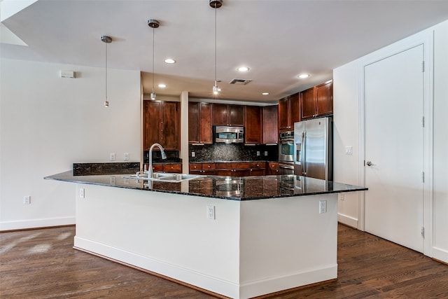 kitchen with decorative light fixtures, dark wood-type flooring, backsplash, stainless steel appliances, and dark stone countertops