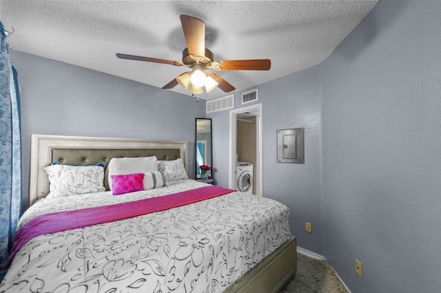 carpeted bedroom with a textured ceiling, ceiling fan, and washer / dryer