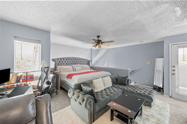 bedroom featuring light colored carpet, ceiling fan, and a textured ceiling