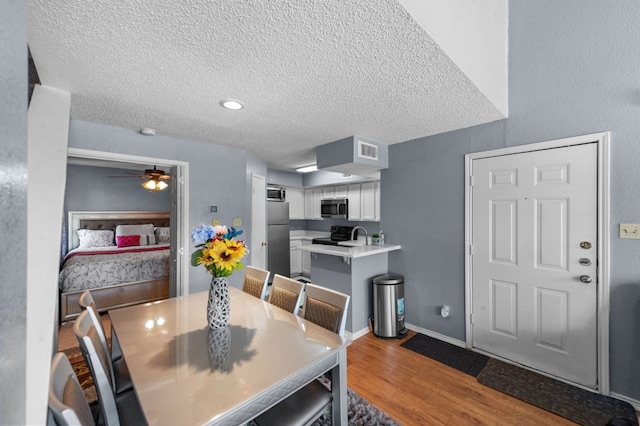 dining area featuring a textured ceiling, ceiling fan, and hardwood / wood-style floors