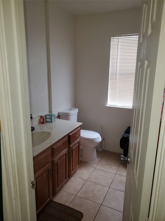 bathroom featuring tile flooring, vanity, and toilet