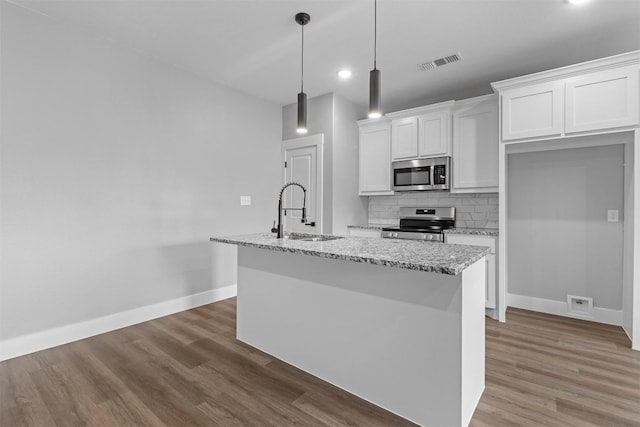 kitchen with a center island with sink, appliances with stainless steel finishes, and white cabinetry