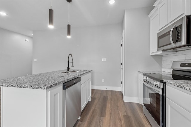 kitchen with appliances with stainless steel finishes, hanging light fixtures, dark wood-type flooring, white cabinetry, and sink