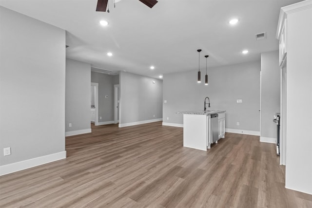 interior space featuring hardwood / wood-style flooring, ceiling fan, and sink