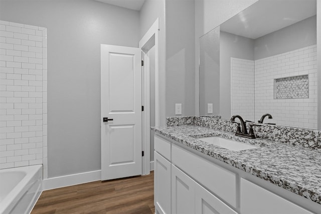 bathroom featuring wood-type flooring, vanity, and tiled shower / bath combo