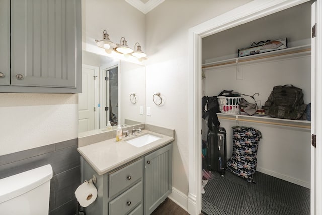 bathroom with vanity, toilet, and crown molding