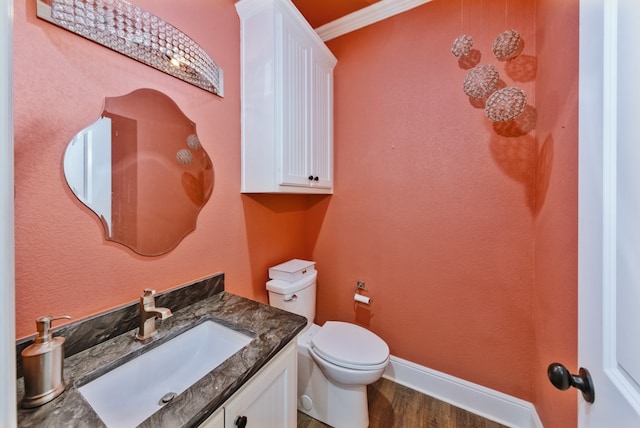 bathroom with wood-type flooring, vanity, toilet, and crown molding