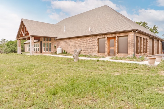 rear view of house featuring a lawn