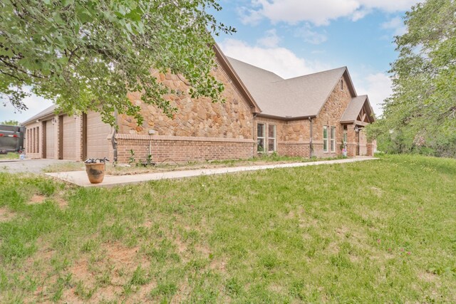 view of side of home featuring a garage and a yard