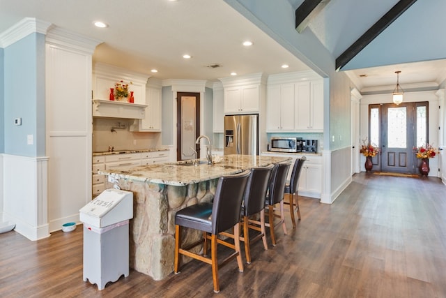 kitchen with dark hardwood / wood-style flooring, a center island with sink, white cabinets, sink, and appliances with stainless steel finishes