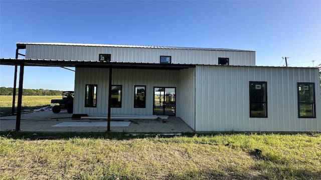 rear view of property featuring a patio area and a lawn