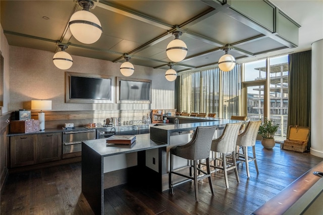 kitchen featuring dark hardwood / wood-style floors, coffered ceiling, expansive windows, and a breakfast bar