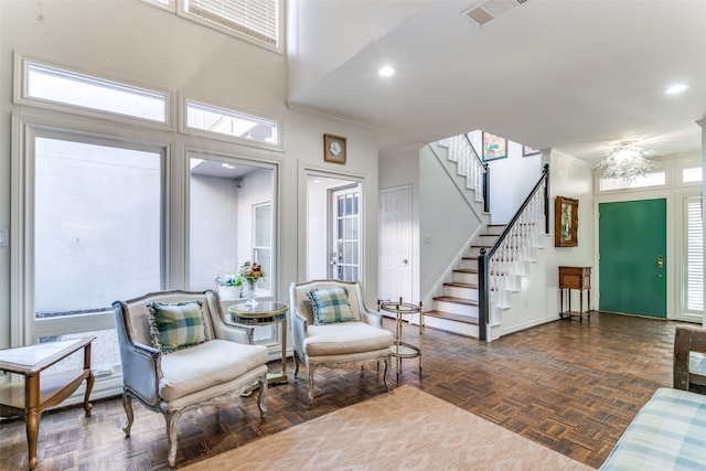 sitting room with crown molding, dark parquet floors, and a high ceiling